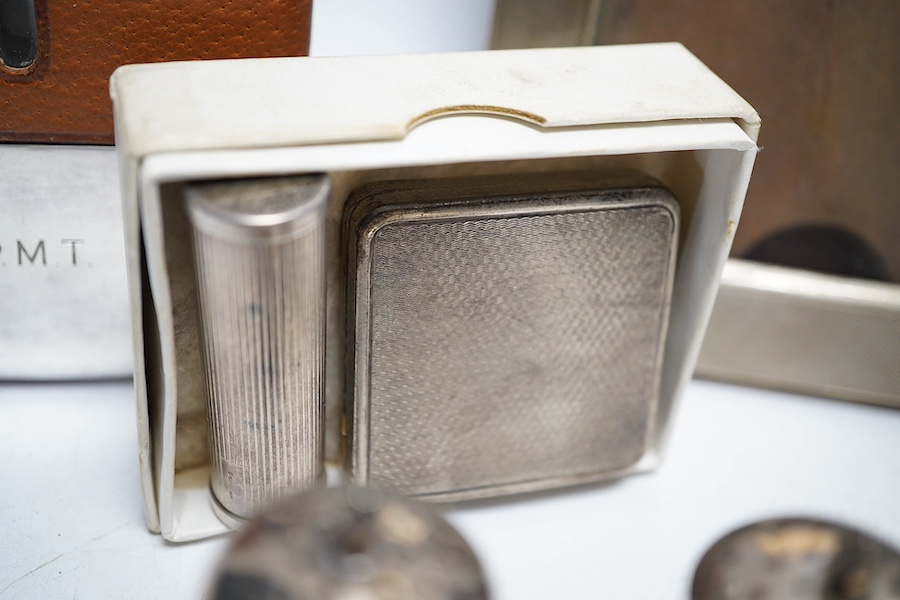 A collection of white metal and hallmarked silver to include three photo frames, a mounted glass flask, a compact, a lipstick holder, a cased pair of Victorian pepper pots, two pairs of Georgian sugar tongs and a mounted